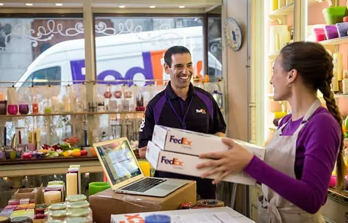 Woman giving fedex packages to fedex courier man