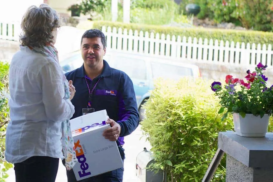 A man is holding a package and talking with a lady