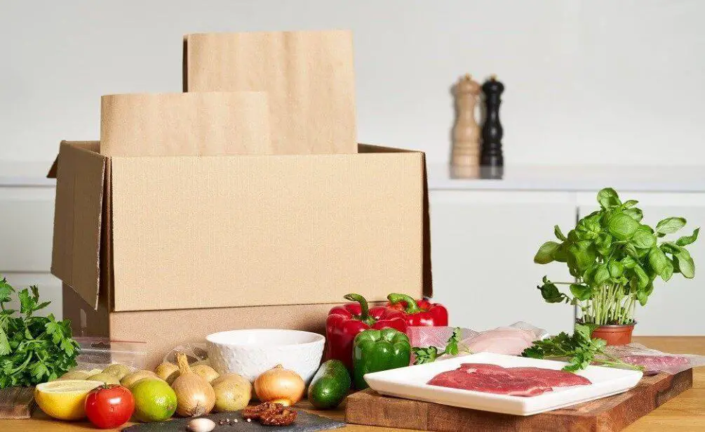 A package box surrounded by fruits and vegetables