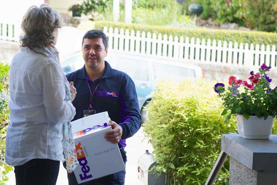 A man is holding a package and talking with a lady