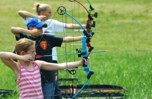 Two girls and one boy shooting arrows